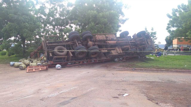 Caminhão carregado com botijões de gás atinge moto e tomba em curva após ficar sem freios
