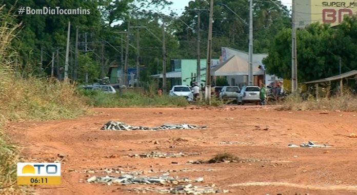 Moradores que estão há anos esperando pelo asfalto tapam buracos com entulho para amenizar problemas